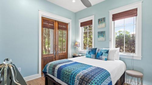 ein blaues Schlafzimmer mit einem Bett und zwei Fenstern in der Unterkunft Serene 30A Getaway Near Beach w Pool Firepit Porch Sea Salt by AvantStay in Grosh