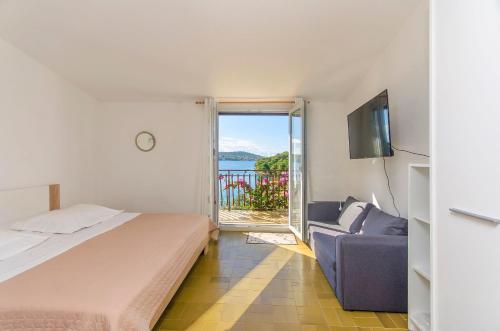 a bedroom with a bed and a tv and a couch at Apartments Marija in Rogoznica