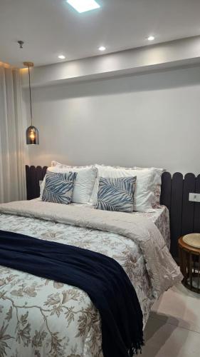 ein Schlafzimmer mit einem Bett mit blauen und weißen Kissen in der Unterkunft Flat Valedo in Palmas