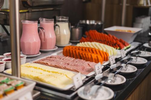 ein Buffet mit verschiedenen Speisen auf einem Tisch in der Unterkunft Hotel Golden Park Curitiba By Nacional Inn in Curitiba