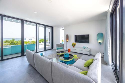 a living room with a couch and a table at Skyline Villas - Villa Pluto Oceanfront with Private Pool in Providenciales