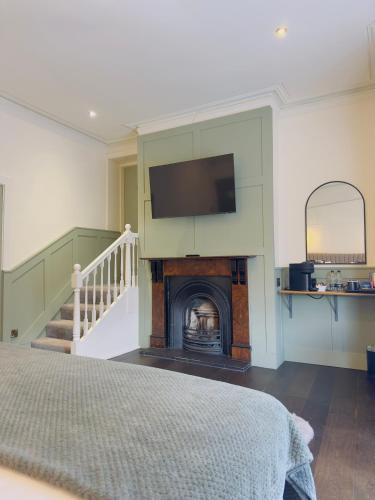 a bedroom with a fireplace with a tv on the wall at The Inn at Cheltenham Parade in Harrogate
