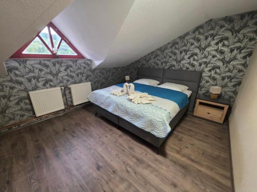 ein Schlafzimmer mit einem Bett mit einer blauen Bettdecke in der Unterkunft Penzion Bedřiška Kraslice in Kraslice