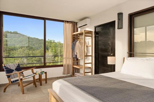 a bedroom with a bed and a large window at Vista Popoyo 3BR Coastal Retreat with Surf & Mangrove Views in Popoyo