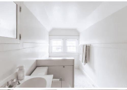 a white bathroom with a sink and a mirror at charming apartment at Lynchburg in Lynchburg