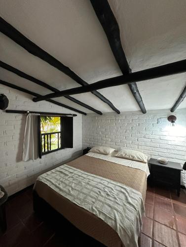 a bedroom with a large bed in a brick wall at Way Maker Santander in Suaita