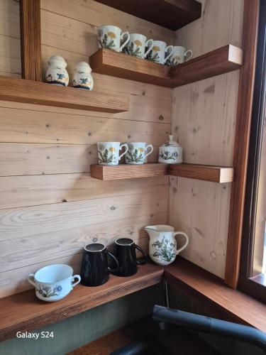 a wooden shelf with cups and bowls on it at Haus Evelynchen auf Rädern Deutschhof in Deutschhof
