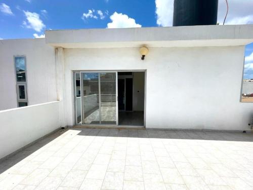 a white building with a large glass door at Appartement Yoff Oasis in Dakar