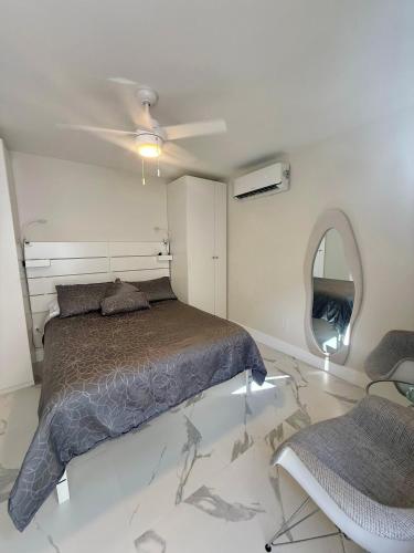 a bedroom with a bed and a ceiling fan at Guayabita's House in Miami