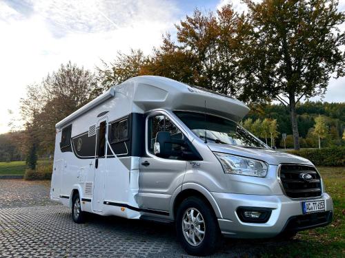 a white camper truck parked in a parking lot at Lodge Camper am Rursee Deine Eifel Auszeit in Simmerath