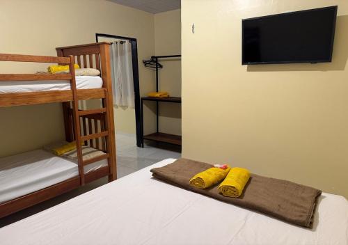 a bedroom with two bunk beds and a flat screen tv at Figueiredo Hosp 4 in Presidente Figueiredo