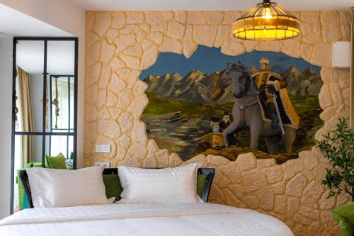 a bedroom with a painting of a horse on the wall at Hotel Castel Suceava in Suceava