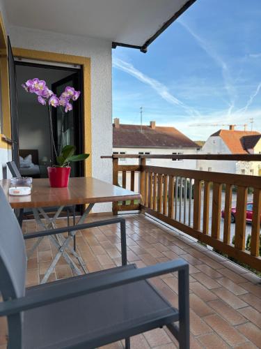 a patio with a table and flowers on a balcony at Gasthof Schrätzenstaller in Hettenshausen
