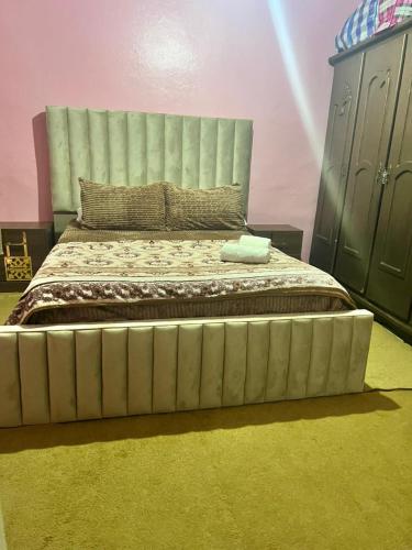 a bedroom with a large bed with a large headboard at Casa Youssef 1 in Asilah