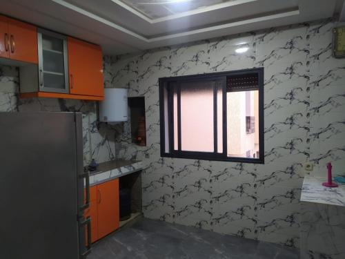 a kitchen with a window in the wall at appartement en résidence - Bouskoura, Maroc 