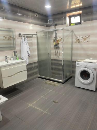 a bathroom with a washing machine and a washer at Уютный дом не далеко от аэропорта in Pʼarakʼar