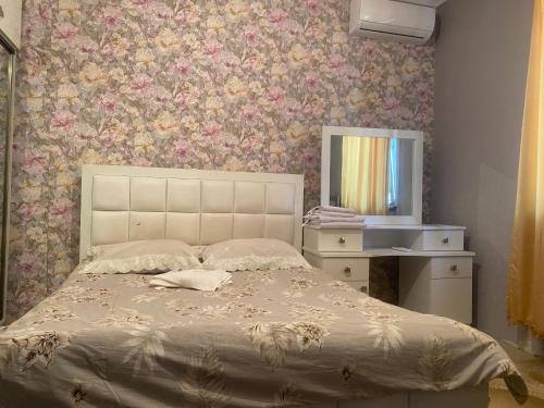 a bedroom with a large bed and a mirror at Уютный дом не далеко от аэропорта in Pʼarakʼar