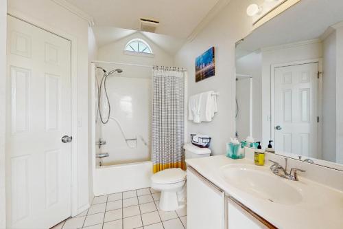 a white bathroom with a toilet and a sink at Shoreline Haven in Kimberling City
