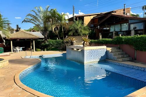 una piscina frente a una casa en Chalé Encanto, Lazer e Piscinas, en Vinicola Girardi