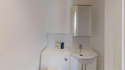 een witte badkamer met een wastafel en een spiegel bij Heart of Notts, Modern Studio, Great City Views in Nottingham