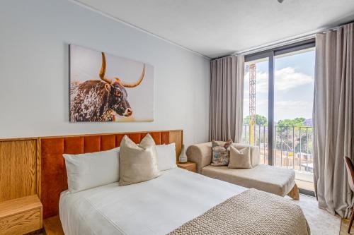 une chambre avec un lit avec un taureau sur le mur dans l'établissement One Rosebank CozyCorner, à Johannesbourg