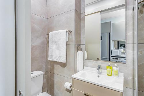 une salle de bain avec un lavabo, des toilettes et un miroir dans l'établissement One Rosebank CozyCorner, à Johannesbourg