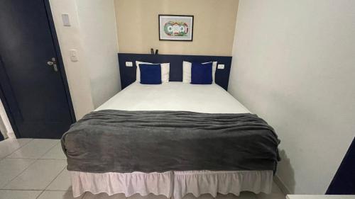 a bedroom with a bed with blue pillows at Copacabana Blue Hotel in Rio de Janeiro