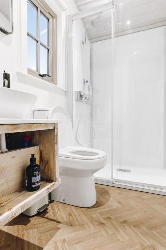 a white bathroom with a toilet and a sink at The Willow - Nestled by the green in Arundel