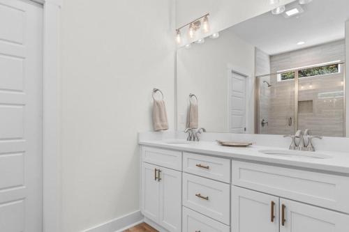 a white bathroom with a sink and a mirror at Munn Hub Live the Dream 4 Bdrm Home with Pool in Pawleys Island