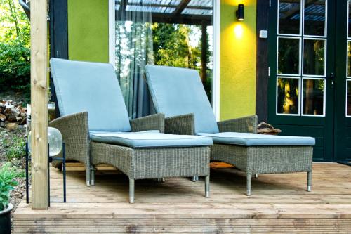 a group of wicker chairs sitting on a porch at Willow Hideaway in Arendonk