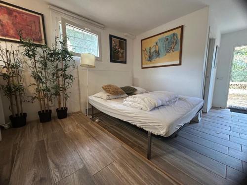 a bedroom with a bed in a room with plants at Casa Fritz in Llagostera