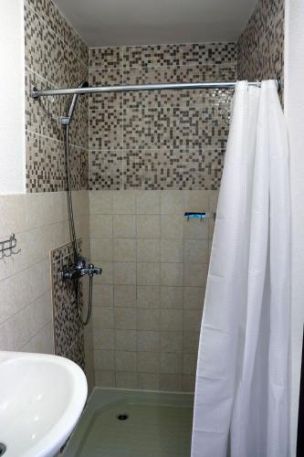 a bathroom with a shower curtain and a sink at Teona-Apartments in Sutomore