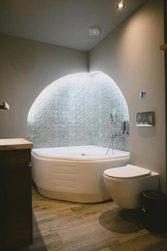 a bathroom with a white tub and a toilet at Downtown Hideaway in Thessaloniki