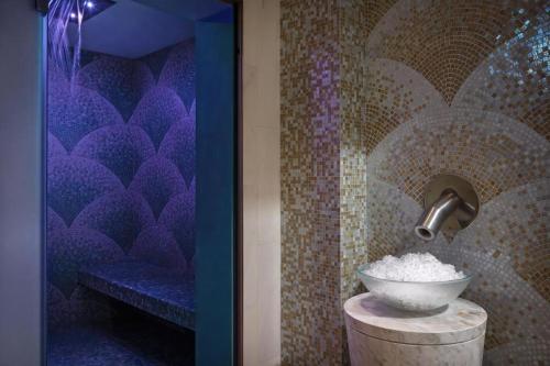 a bathroom with a bowl on a table in a room at Address Marassi Residence, Bahrain in Manama