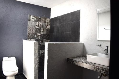 a black and white bathroom with a sink and a toilet at Bounaterra Lofts in León