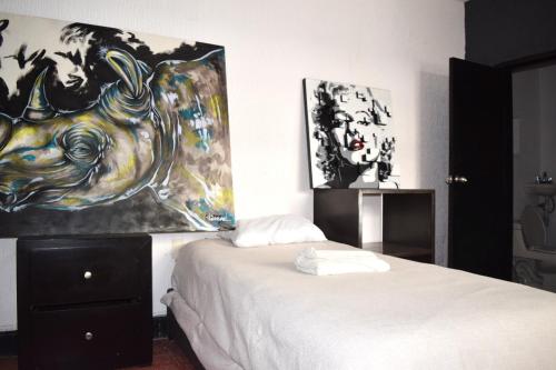 a bedroom with a bed with a painting on the wall at Bounaterra Lofts in León