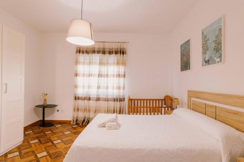 une chambre avec un lit blanc et une fenêtre dans l'établissement Casa rural Gómez de Hita, à Caravaca de la Cruz