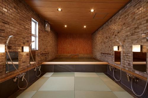 a bathroom with a brick wall at Wakamatsu Honten in Narita