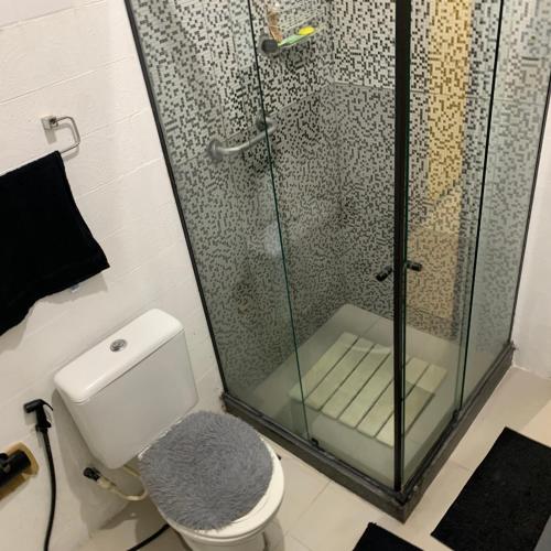 a bathroom with a shower and a white toilet at Quarto vista mar in Rio de Janeiro