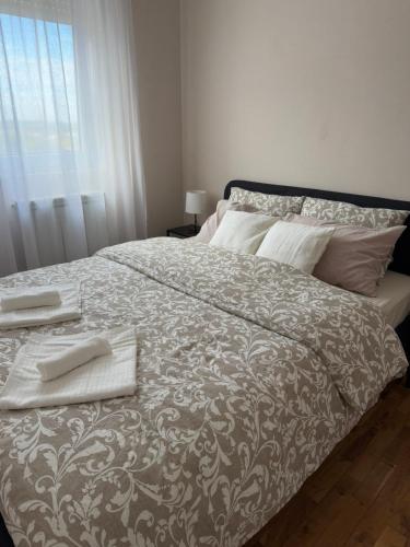 a bedroom with a large bed with two towels on it at Kutak mira in Belgrade