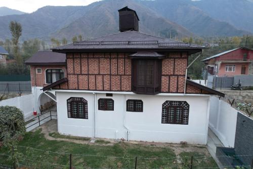 a house with a roof with mountains in the background at Ninive Homestay in Nu Chid