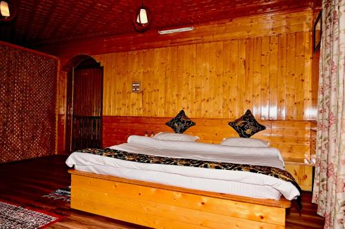 a bedroom with a bed in a wooden wall at Ninive Homestay in Nu Chid