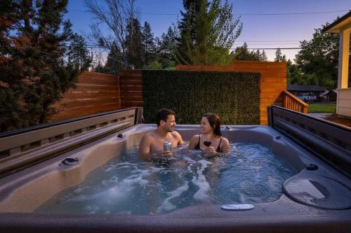 a man and a woman sitting in a hot tub at Snowcreek Suite - Hemlock in Leavenworth