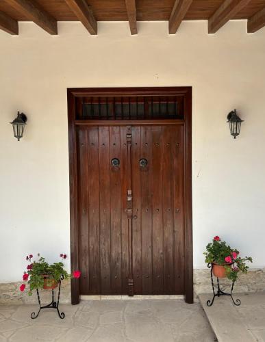 a wooden door with two plants in front of it at Calypso Historic Village House in Limassol