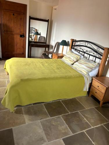 a bedroom with a bed with a green blanket on it at Calypso Historic Village House in Limassol