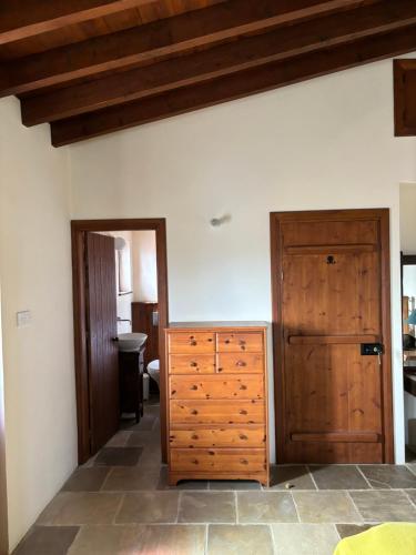 a bedroom with a dresser and a wooden door at Calypso Historic Village House in Limassol