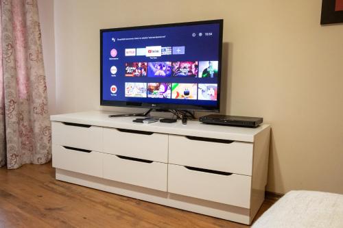 a television on a white dresser in a room at Cozy and warm apartment with a separate bedroom in Bansko