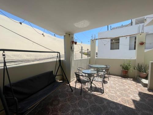 a balcony with a table and chairs and a couch at Hospedaje Mayo Huacachina in Ica