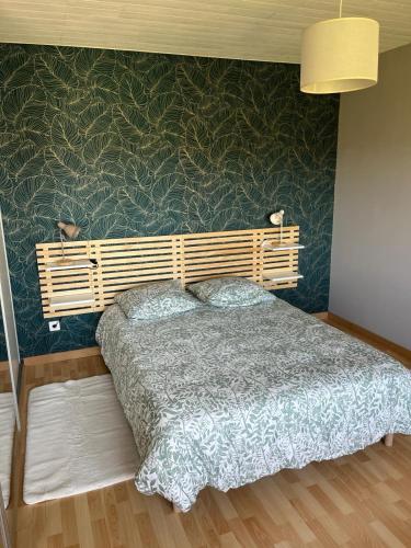 a bedroom with a bed and a green wall at Maison de campagne Lac de Vouglans in Onoz