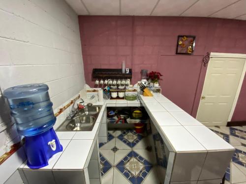Una pequeña cocina con fregadero y estufa. en Casa Cahuí, en El Remate